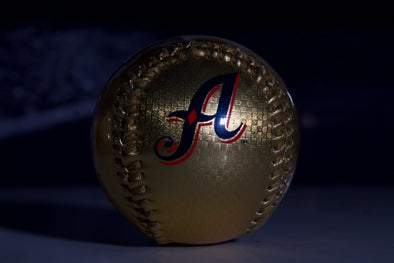 Gold baseball with a logo on a dark background