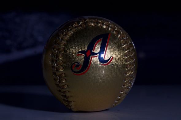 Gold baseball with a logo on a dark background